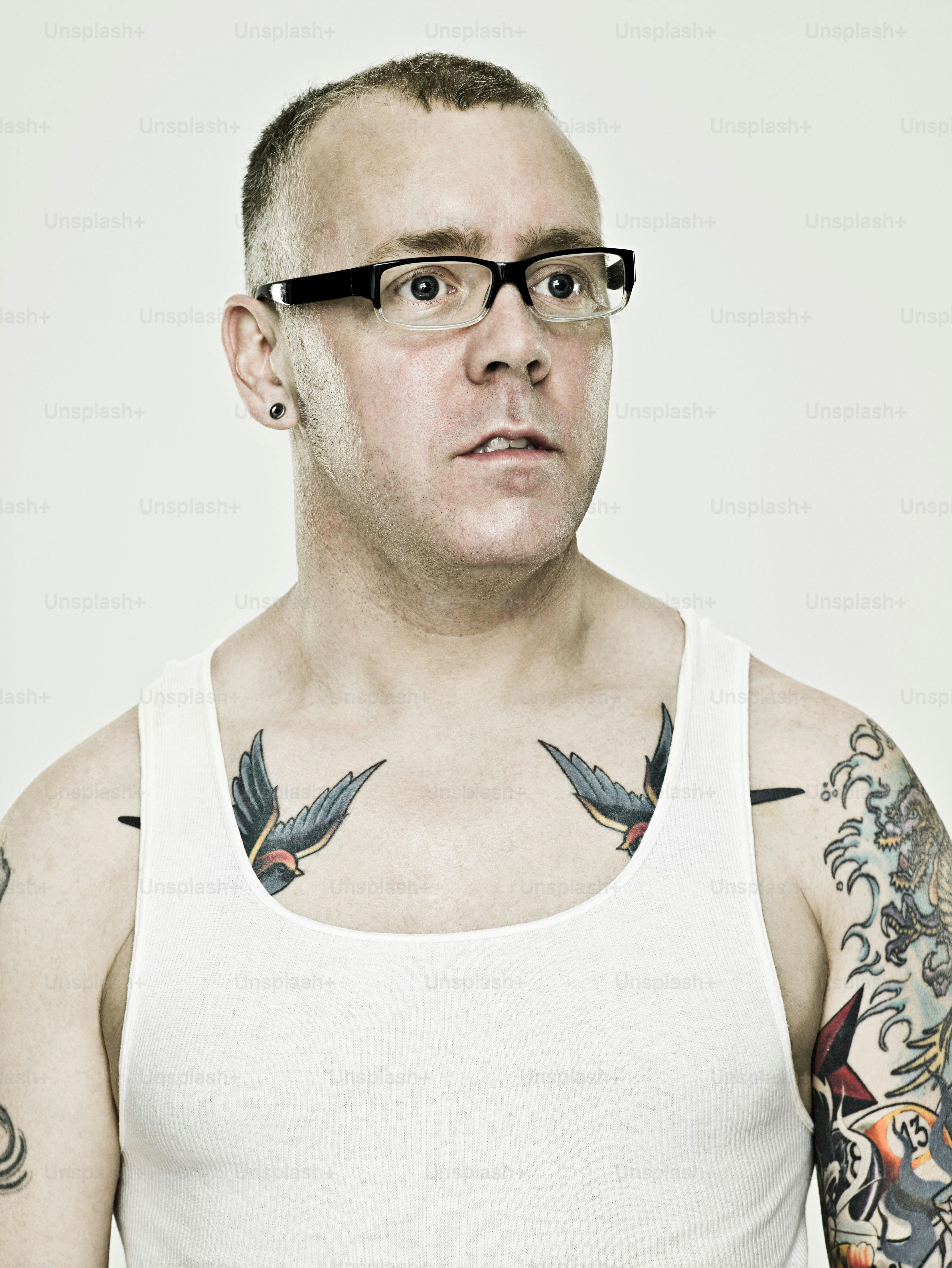 A man with tattoos on his chest wearing a tank top photo – Tattoo Image on Unsplash